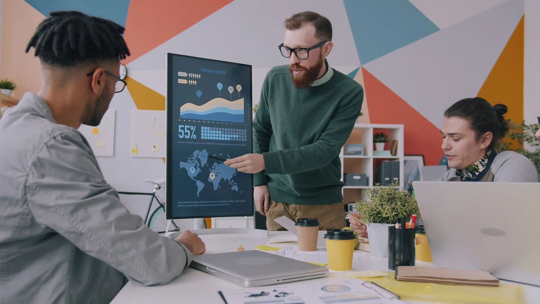 Colaboração em equipe na estratégia de crescimento dos negócios com gráficos de dados em um escritório moderno.